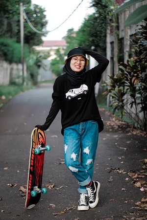 Young woman holding a skateboard